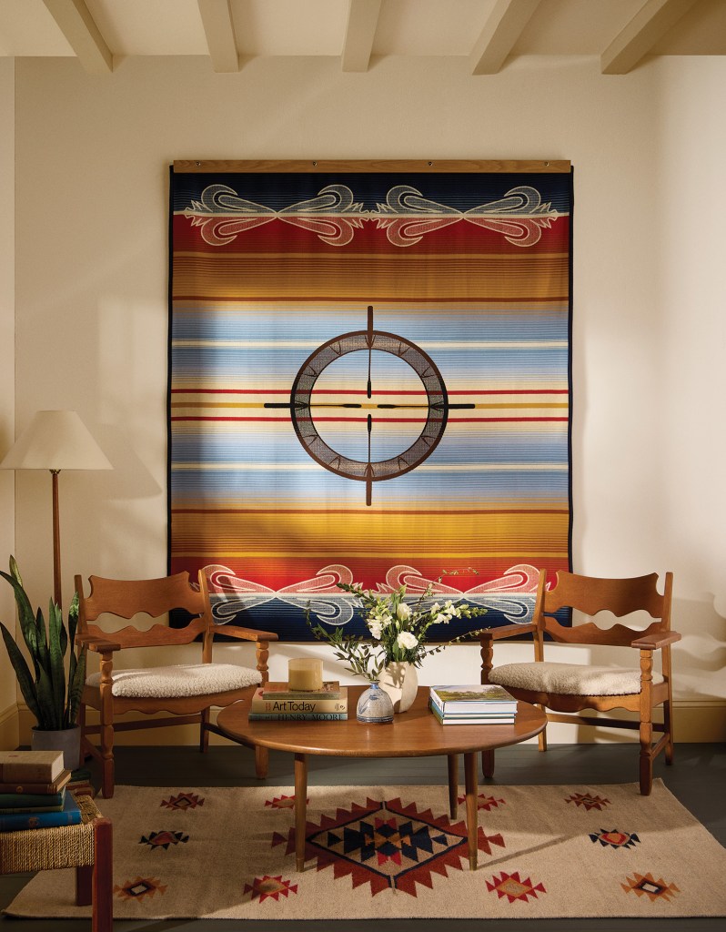 The Drum Keepers blanket hanging in a living room setting.