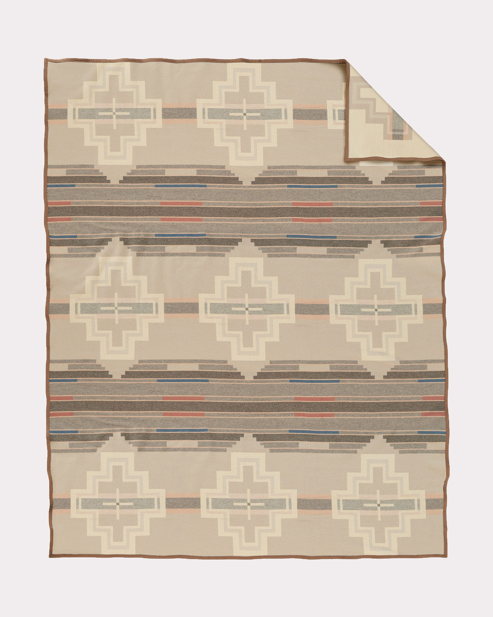 The Santa Clara blanket by Pendleton is a geometric pattern in shades of creme, taupe and beige, with mall accents of rust and marine blue.