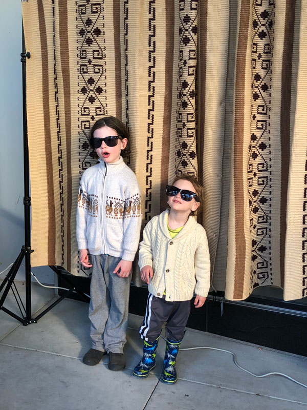 Two young boys pose, dresses in their Dude costumes, at DudeCon's photo booth.