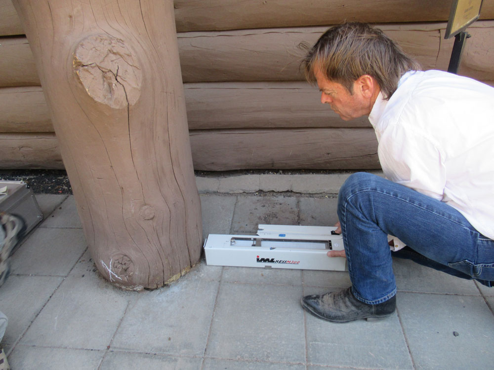 A man works on the exterior of the Grand Canyon Depot building.