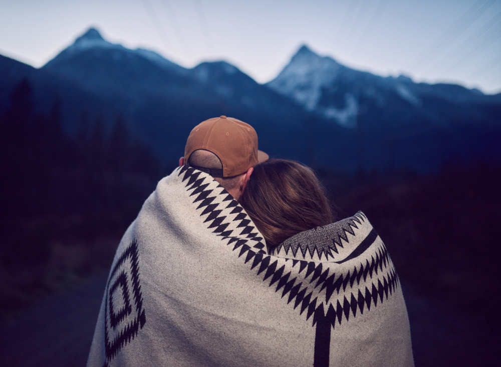 Sean and Tam look at the mountains while wrapped in a Pendleton blanket