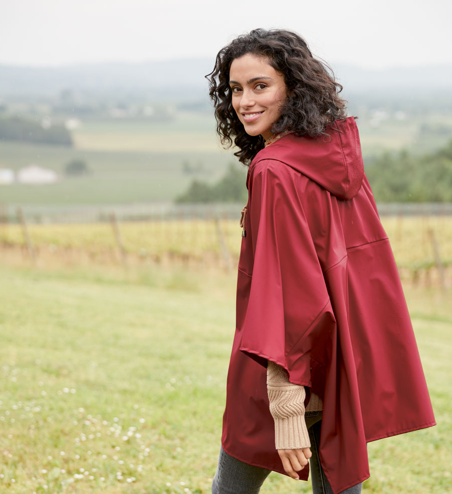 A woman in a field wearing a red Pendleton rain poncho.