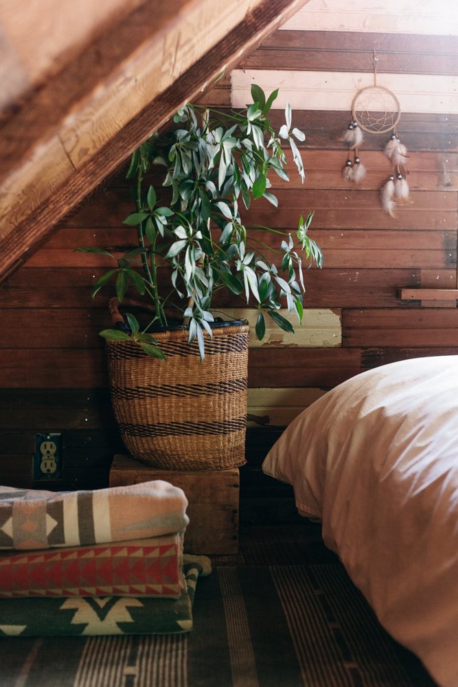 A stack of wool blankets at the foot of a bed.