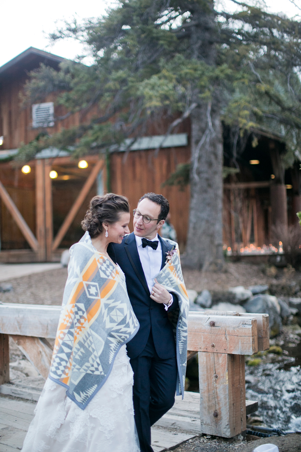 The couple, wrapped in a Pendleton blanket, walks the venue grounds.