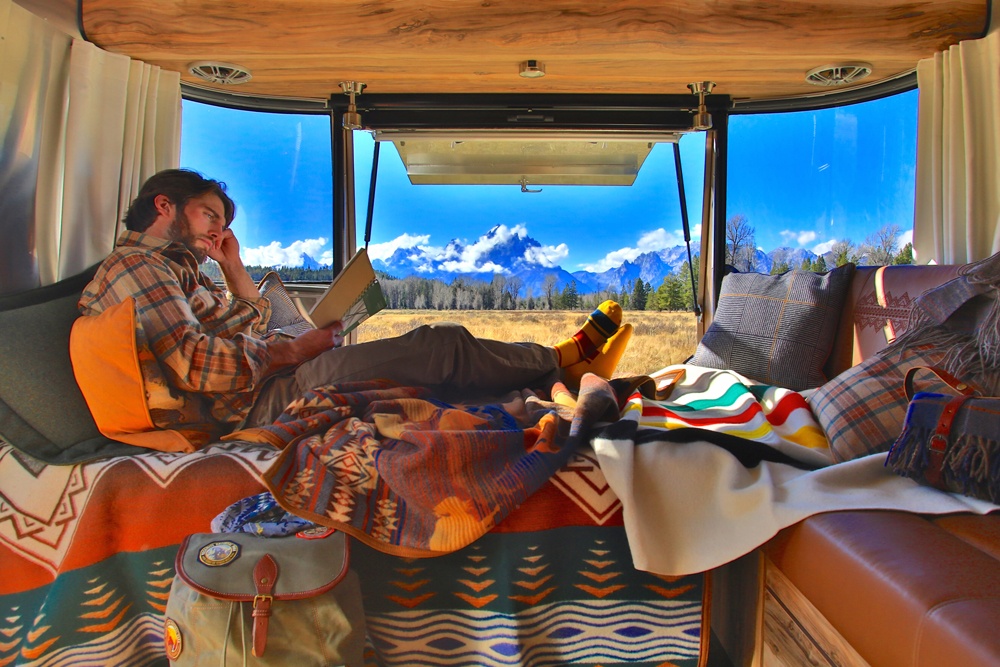 A man sits on the banquette of the Pendleton Airstream, surrounded by Pendleton blankts