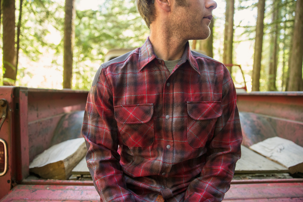 a man sits on the tailgate of a vintage pickup truck, wearing a Pendleton Kitsbow shirt