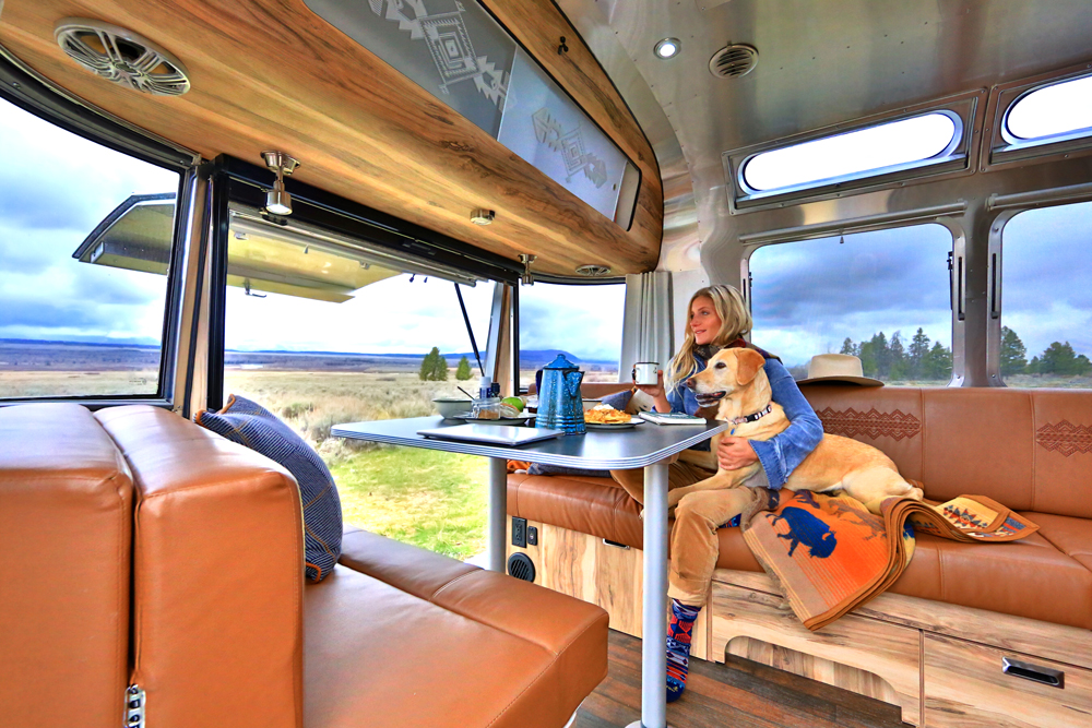 Woman with yellow Labrador dog sits on the banquette