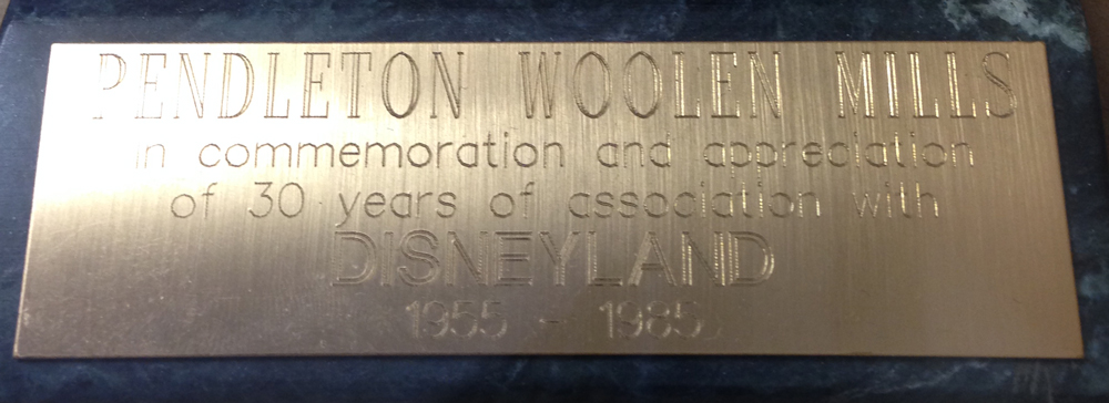 A closeup of the plaque affixed to the base of the Jiminy Cricket bronze that reads "Pendleton Woolen Mills in commemoration and appreciation of 30 eyars of association with Disneyland 1955 - 1985"