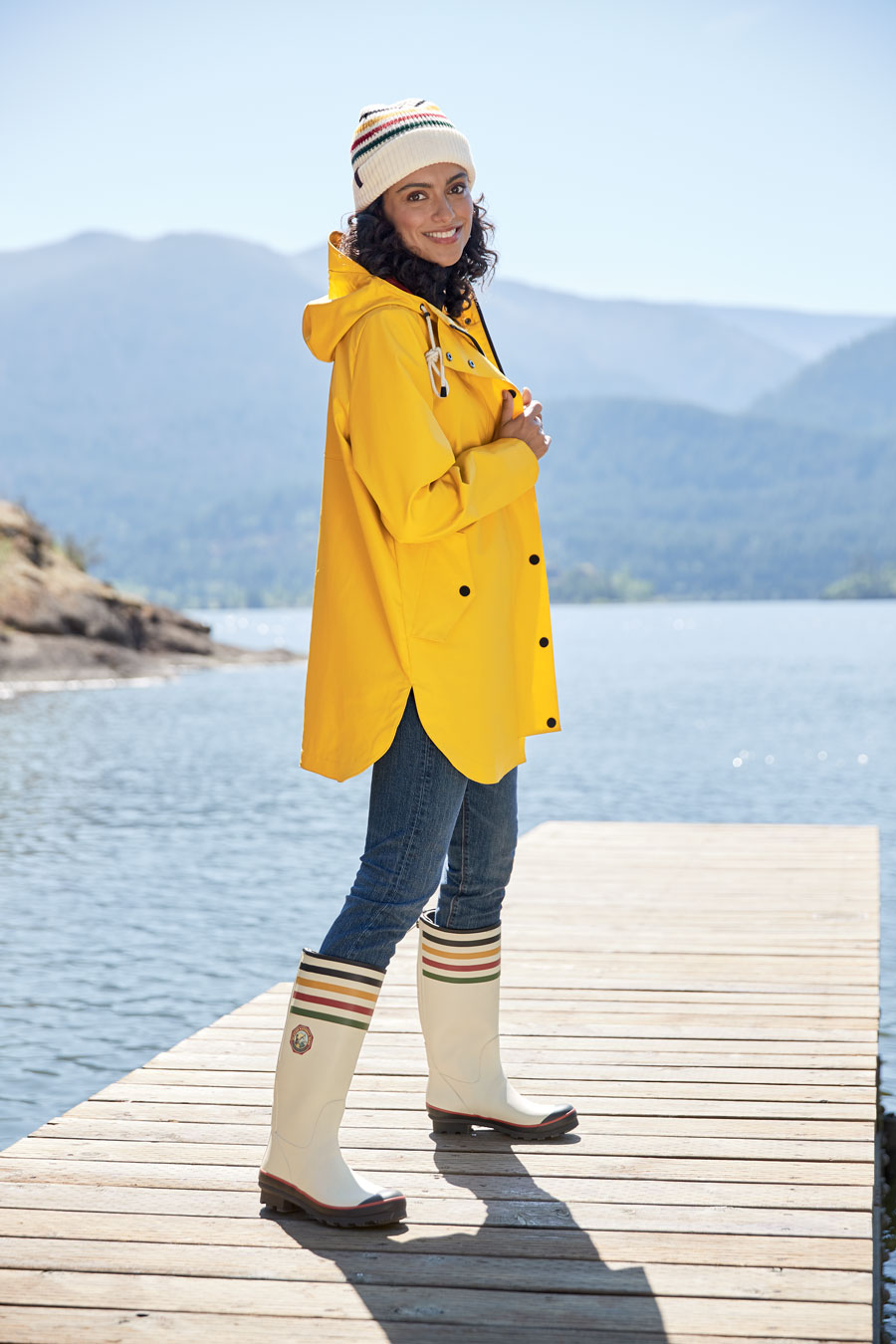 woman in Pendleton rain slicker and boots standing on a dock