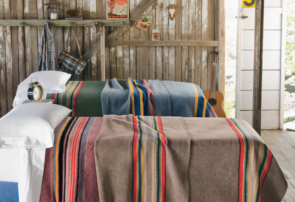 Camp blankets on beds in a rustic cabin