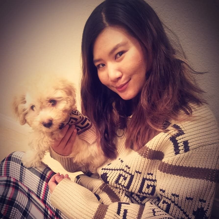 A woman holds a small dog, both are wearing Westerle sweaters