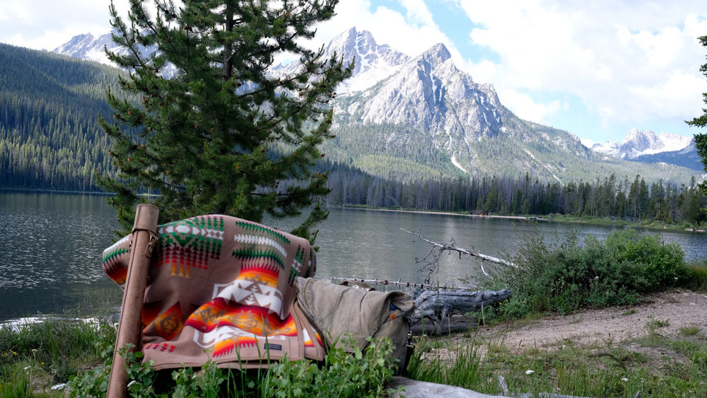 A stunning photo of the Chief Joseph blanket by Pendleton, against the backdrop of a snowcapped peak and a river. Photo by Greg hatten.