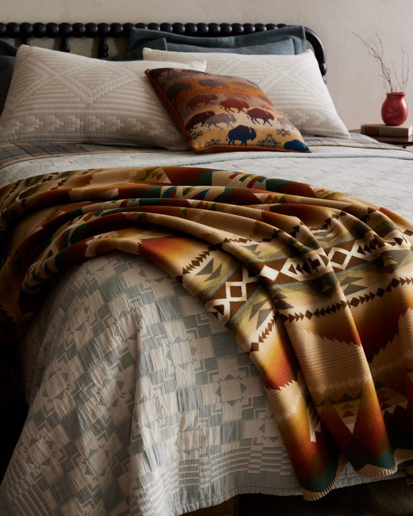 The Solstice Canyon blanket on a bed with other Pendleton bedding