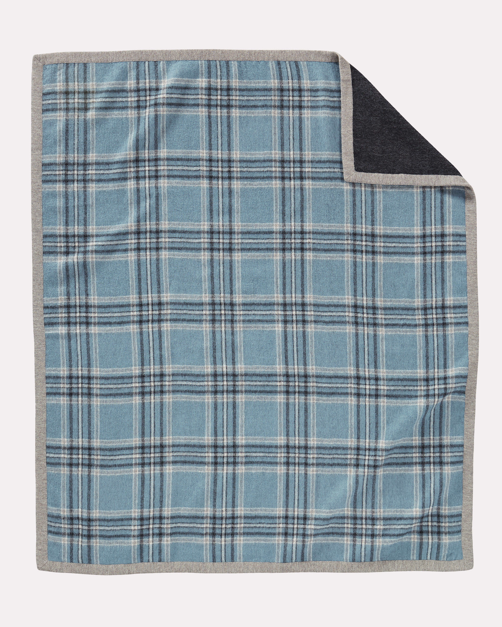 A reversible alpaca throw. One side is a blue/grey plaid, the other is charcoal grey, with a light grey binding.