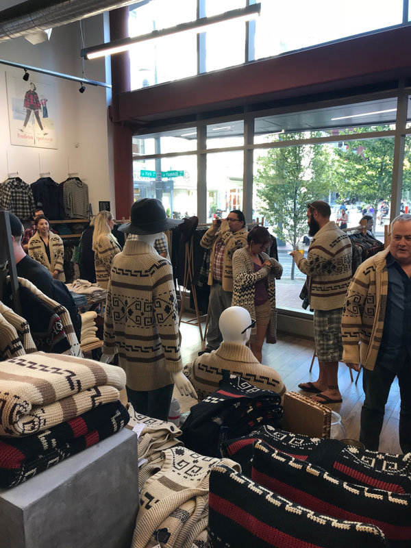 A shot of partygoers in front of the tall store windows of the Pendleton store