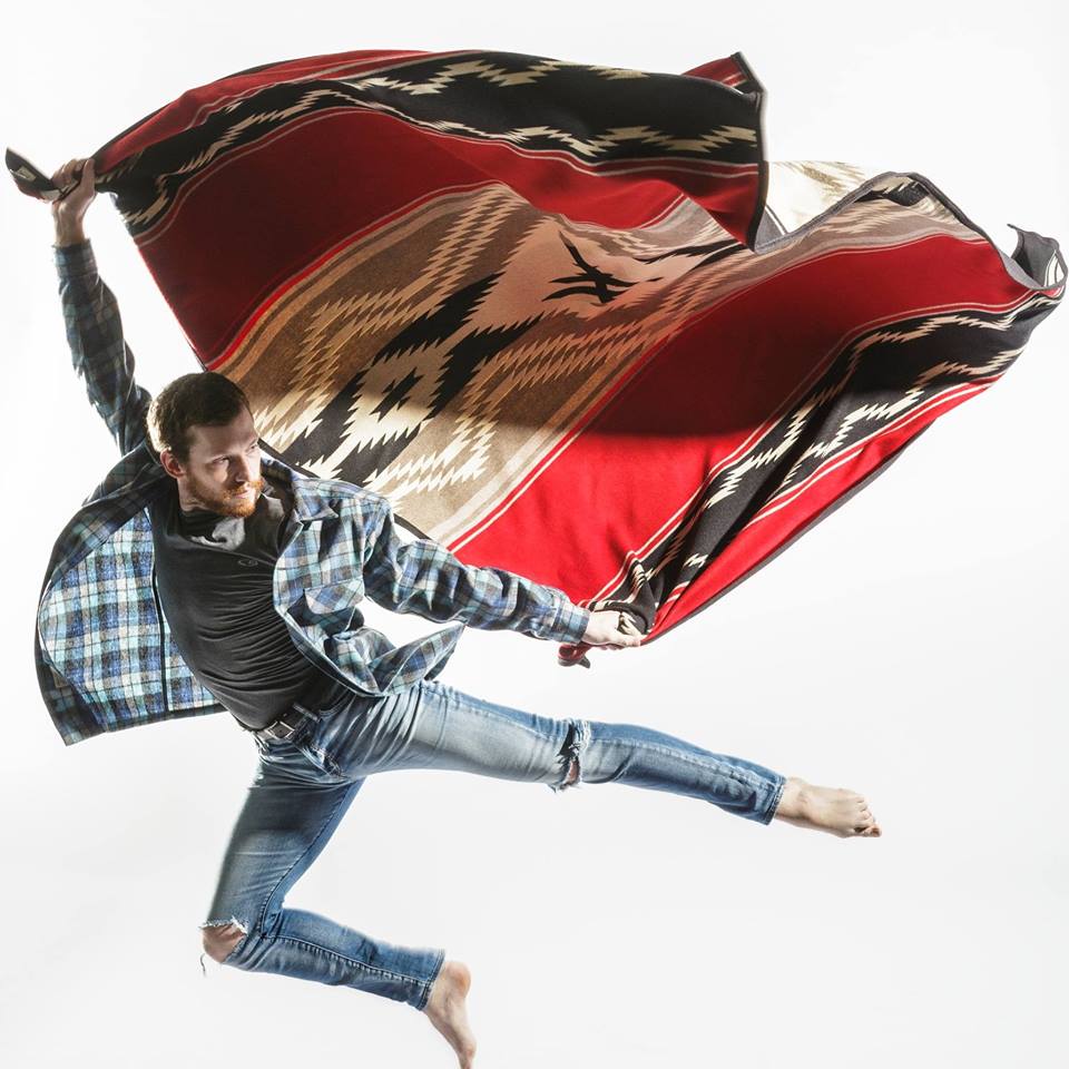 A dancer from the BodyVox company leaps in the air with a Pendleton Water blanket.