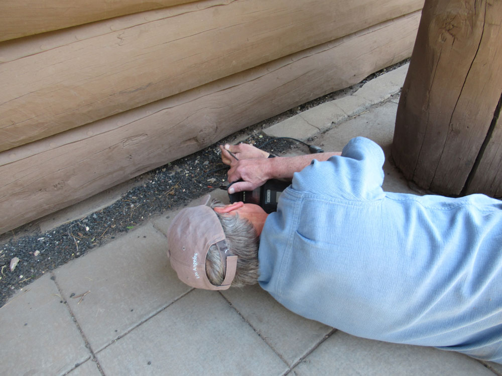 A man works on the exterior of the Grand Canyon Depot building.