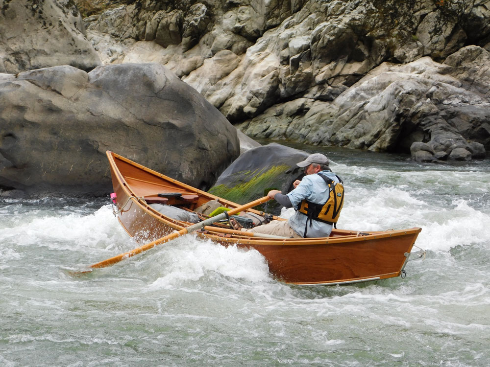 Greg Hatten steers his wooden drift boat through the rapids on the Rogue River.