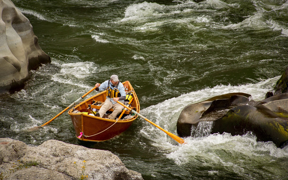 Greg Hatten steers his wooden drift boat through the rapids on the Rogue River.