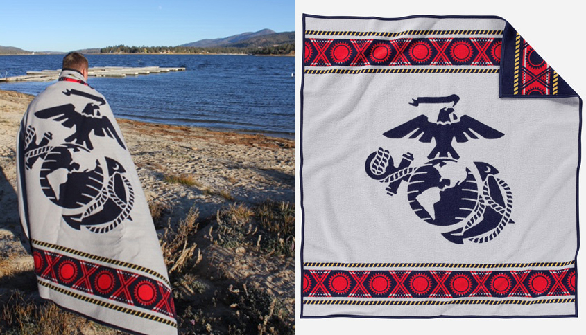 Man stands on shore of lake with USMC blanket.