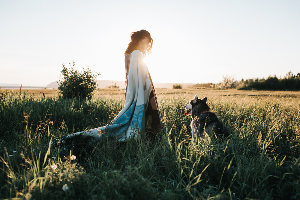 Grace_Adams A woman and her dog stand in a meadow