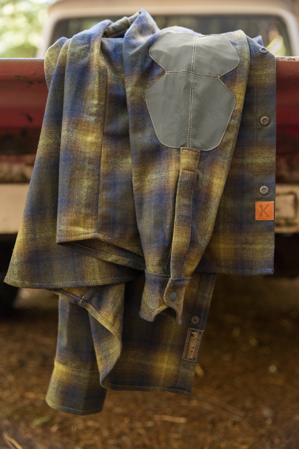 a Pendleton Kitsbow shirt draped over the side of a vintage pickup truck