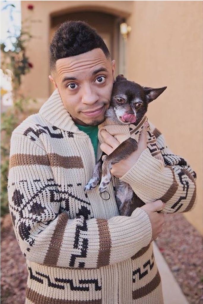 Man holds a small chihuahua, they both are wearing Westerley sweaters