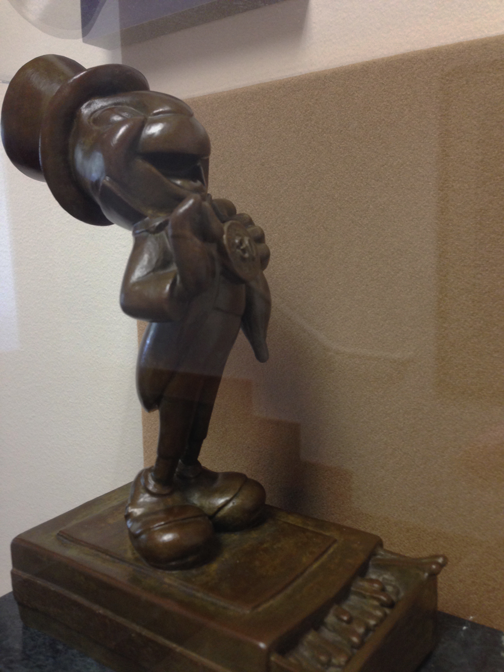 A side view of a small bronze statue of Jiminy Cricket, gifted to Pendleton by Walt Disney.