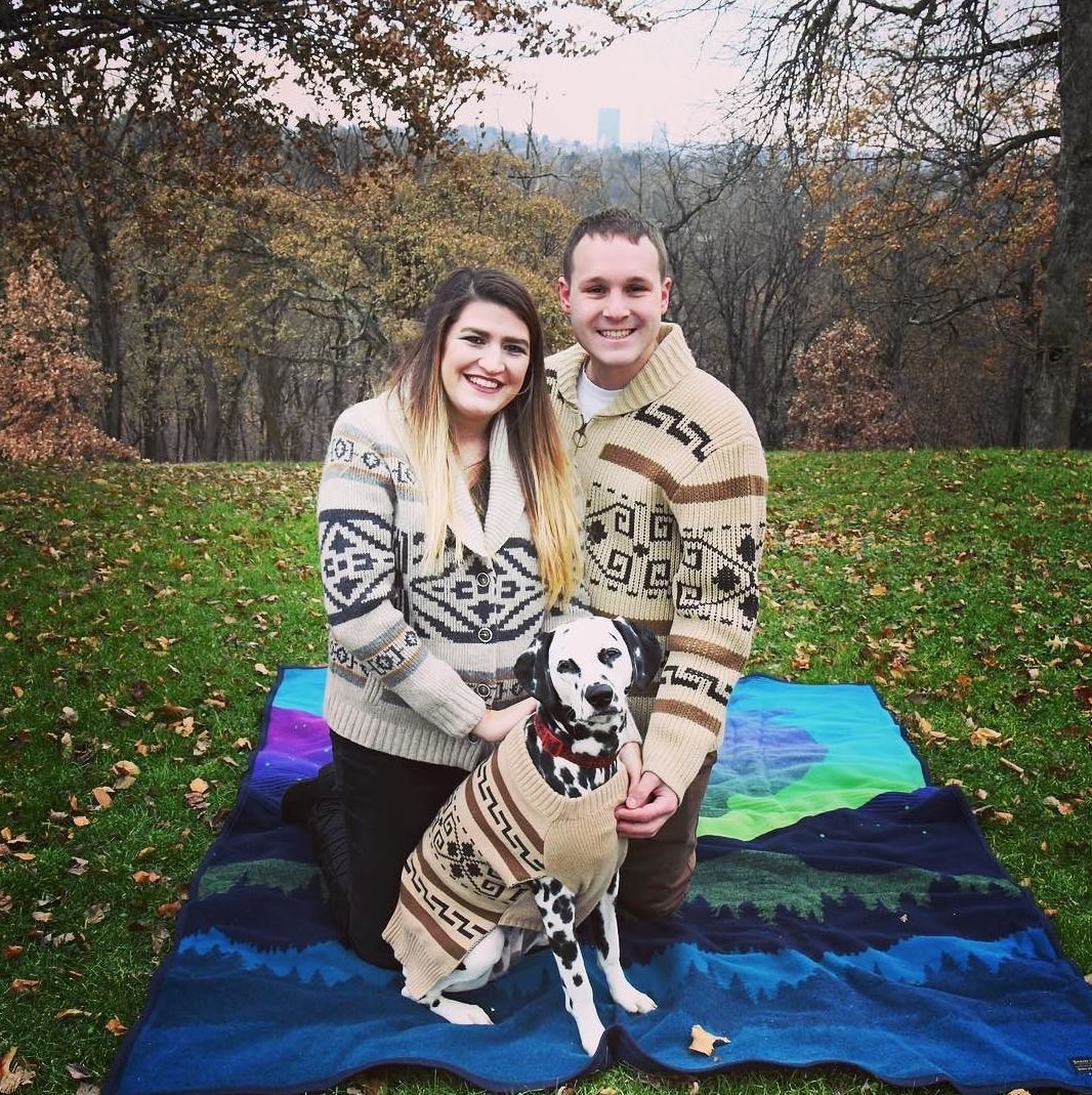 A couple sits on a Pendleton blanket with their Dalmation dog, all wearing Westerley sweaters