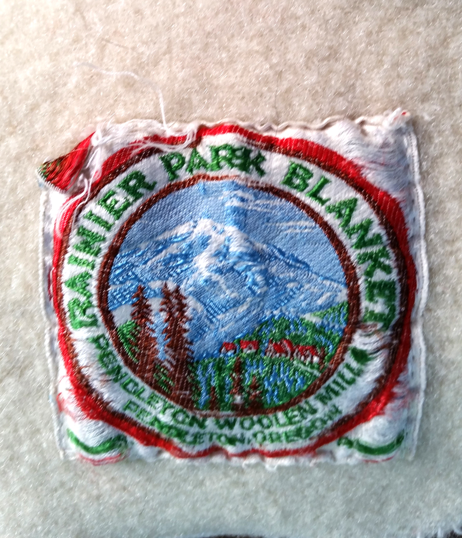 Photo of a blanket label for a Rainier National Park blanket from the 1940s.