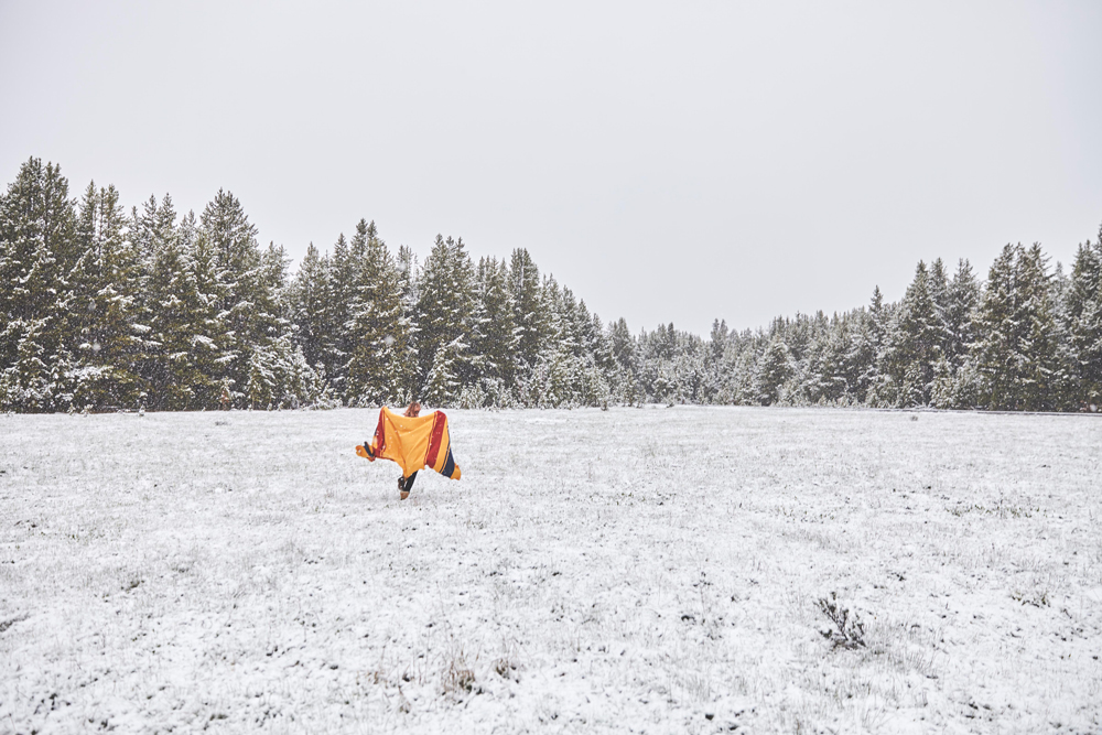 OurFreeWays_ A woman runs across a snowy field