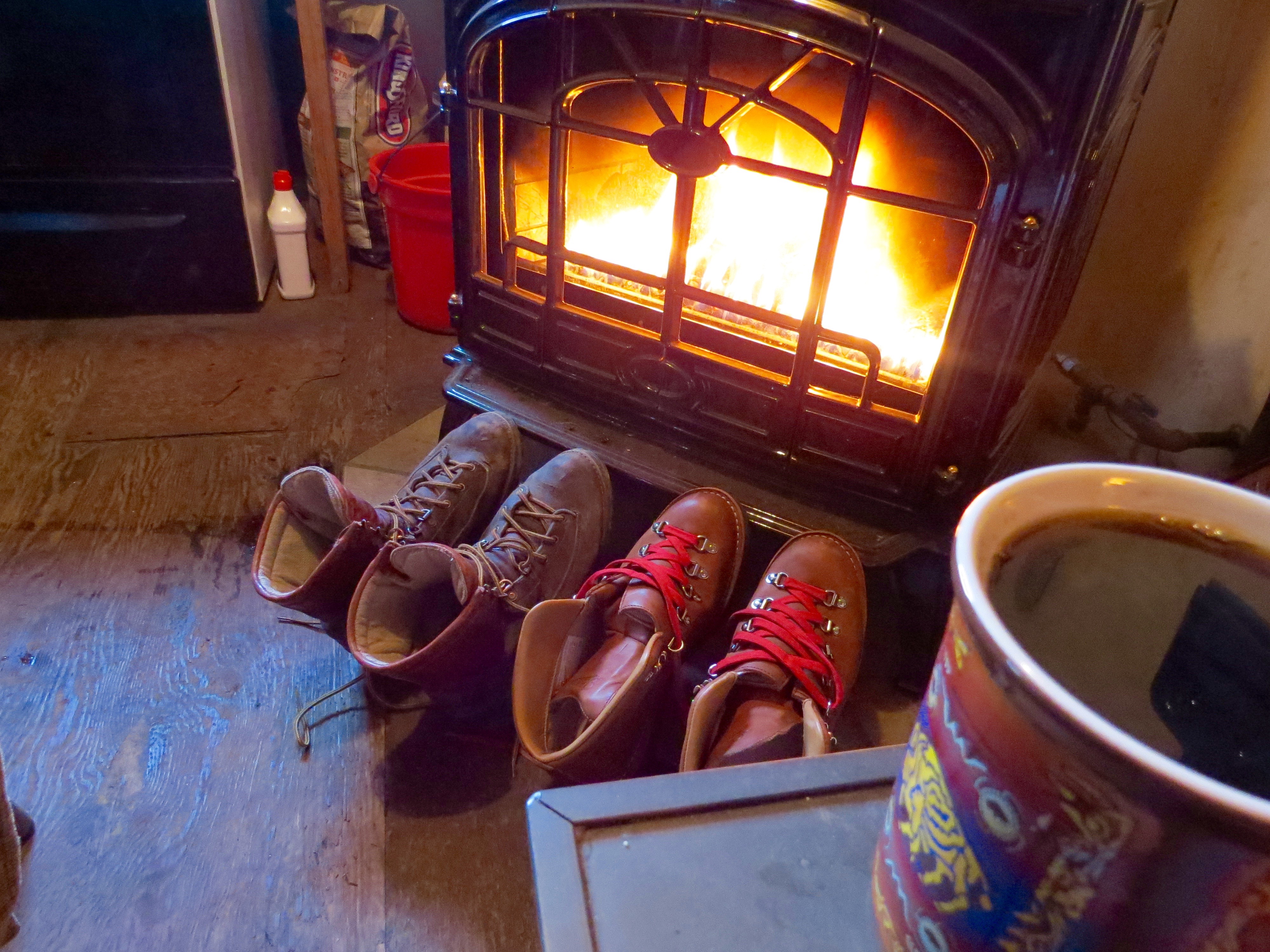 Boots dring by the woodstove with a Pendleton Buffalo Creation coffee mug in the foreground.