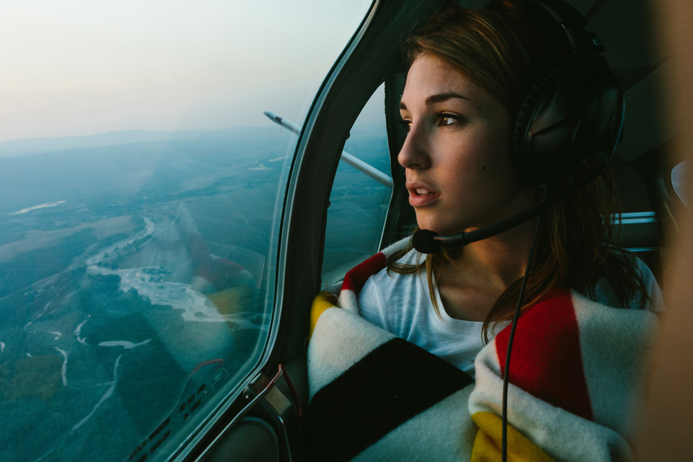 Irey_ A woman looks out the window of a small plane