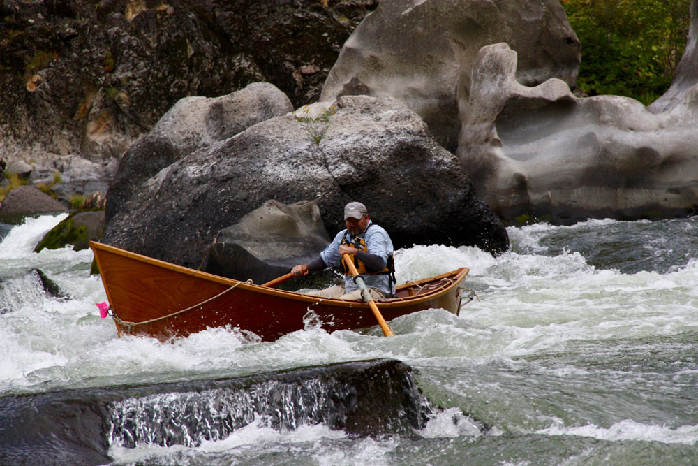 Greg Hatten steers his wooden drift boat through the rapids on the Rogue River.