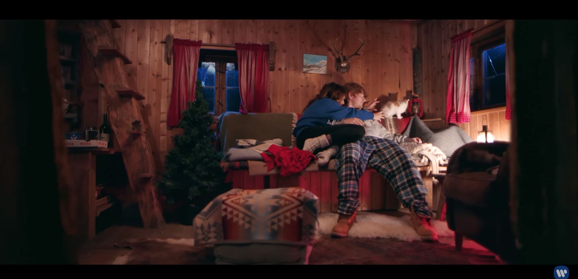 Screen shot from "Perfect" video by Ed Sheeran of a couple on a sofa in a cabin