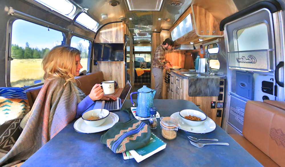 A woman sitting at a table in the Pendleton Airstream