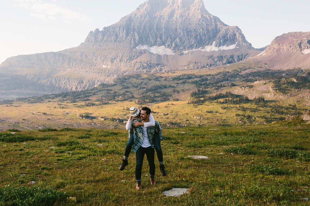 Irey_A man and woman in front of a glacier. He is giving her a piggyback ride.