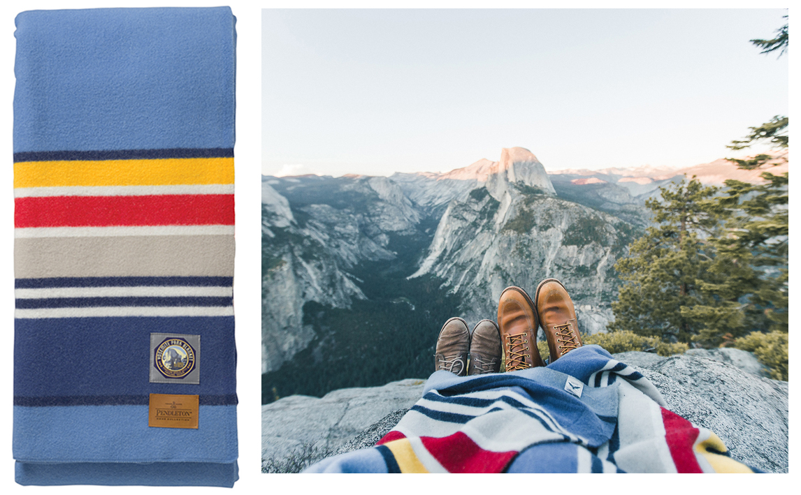 Yosemite park blanket, folded, next to a couple enjoying a mountaintop view of Yosemite