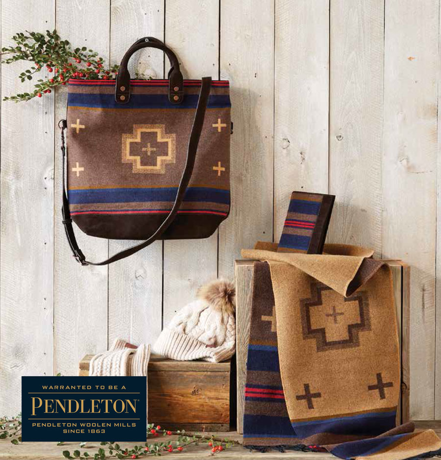 Pendleton bag, scar and hat sitting on a wooden table against a shiplap background.