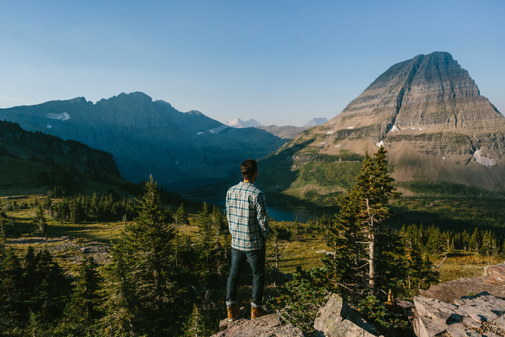 Irey_A man stands on a rocky outcropping looking at a glacier