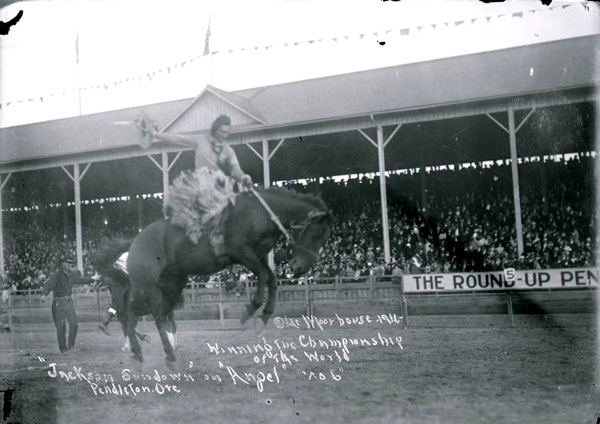 A rare photo of Jackson Sundown riding in the Pendleton Round-Up Arena. The photo has been written upon, and these are the words: "Moorhouse 1916 - Winning the Championship of the World 'Jackson Sundown' on 'Angel' 'no 6' Pendleton Ore"