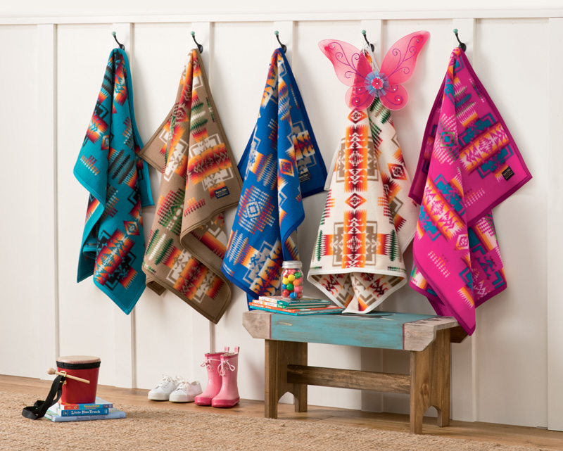 Five Pendleton child-sized blankets hang on pegs.