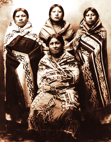 Archival photo of Native American women wrapped in Racine blankets. 