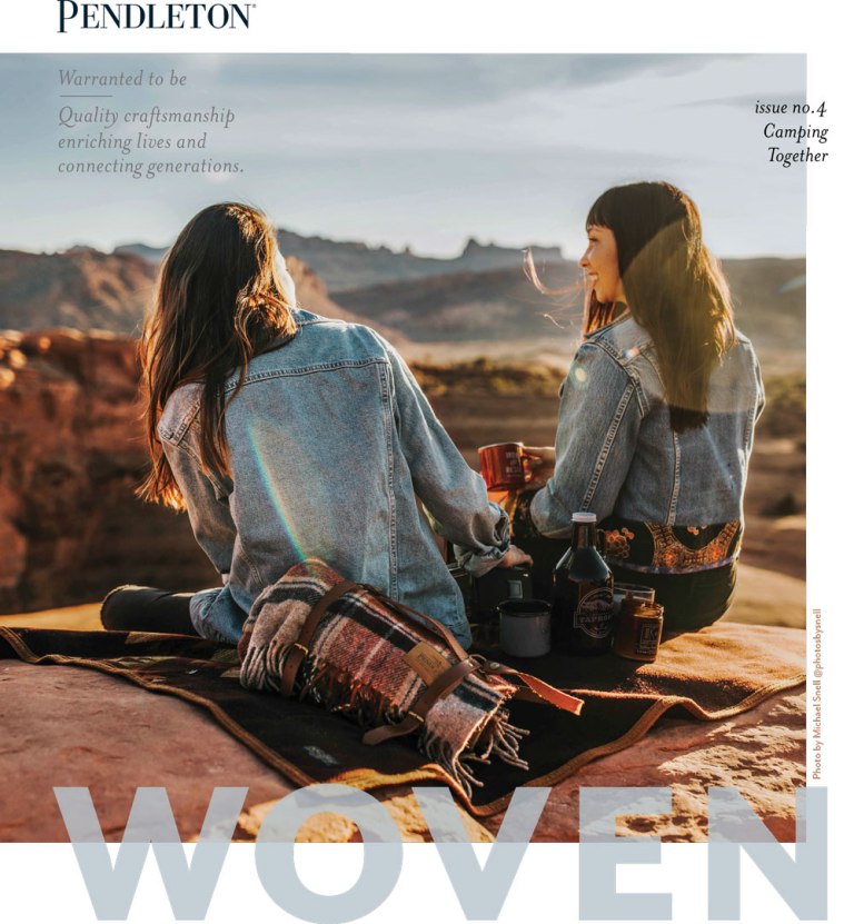 Pendleton WOven magazine cover for Spring 2019, two young women sit on a Pendleton plaid throw, overlooking a red rock canyon. 