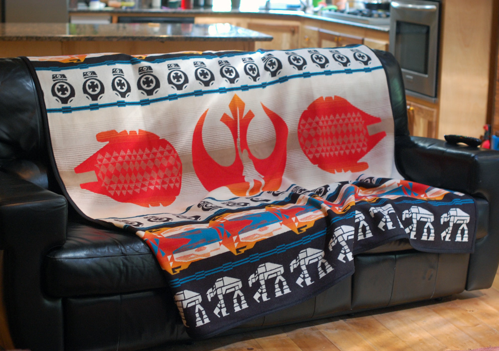 The last Jedi blanket on a black leather couch.