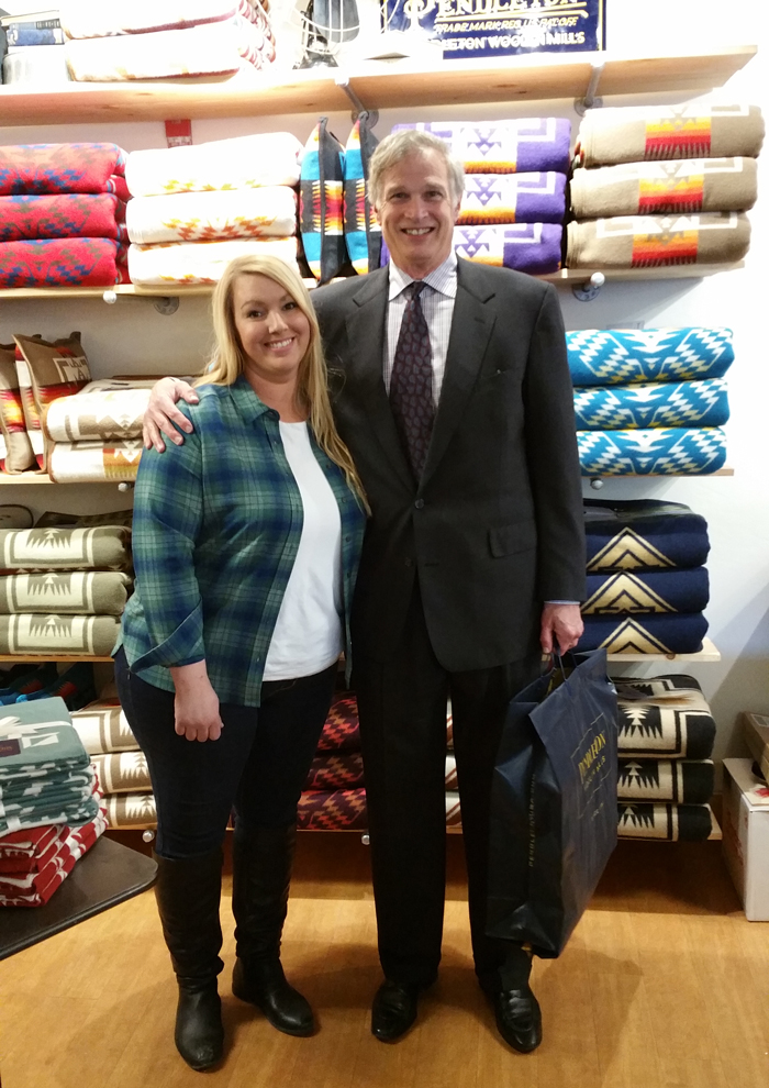 The Eugene Pendleton store's first cutomer poses with a store sales associate in front of the blanket wall.