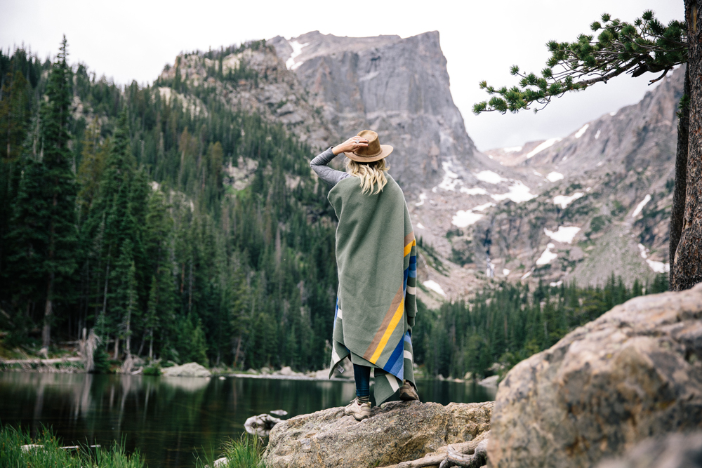 Kate Rolston photo of a woman at the lakeshore wrapped in a Pendleton Rocky Mountain National park blanket. 