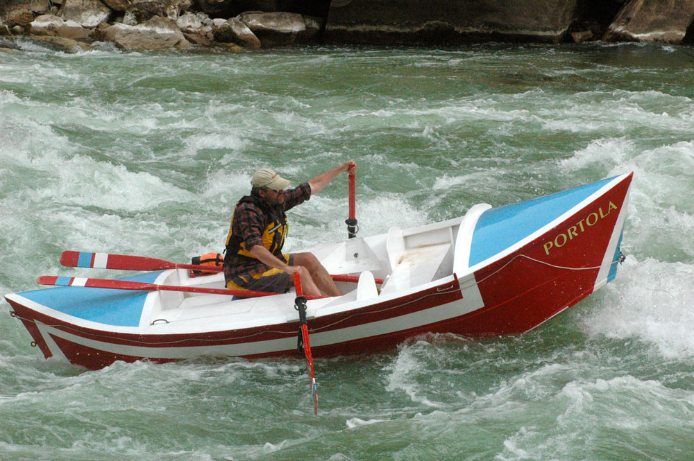 Greg Hatten maneuvers his way though churning rapids in his wooden boat, the "Portola."