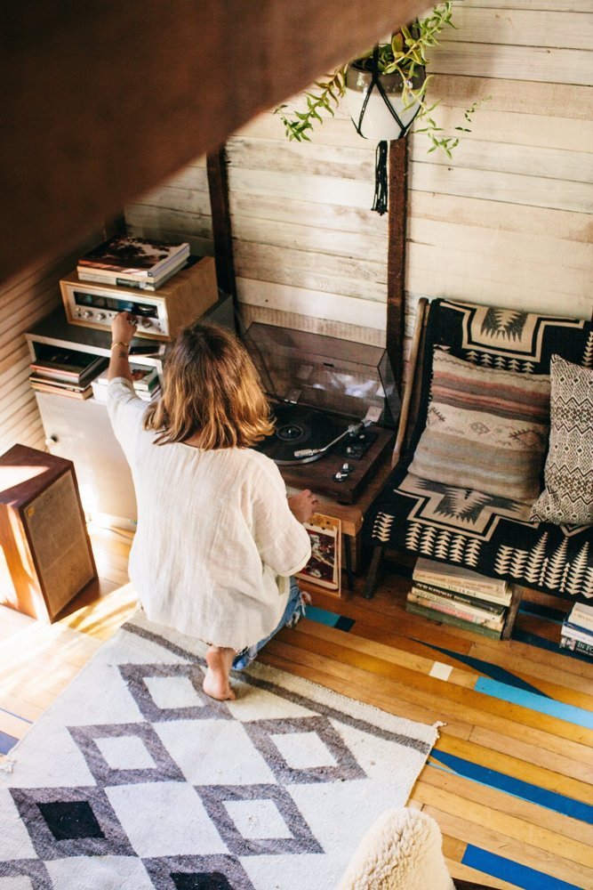 A woman adjusts the sound on a stereo in her tiny home.