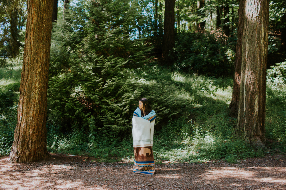 Cassy_Berry_a woman stands in the forest, wrapped in the blanket